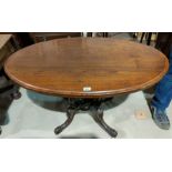 A Victorian walnut centre table with oval top on 4 turned columns, carved splay feet and castors,