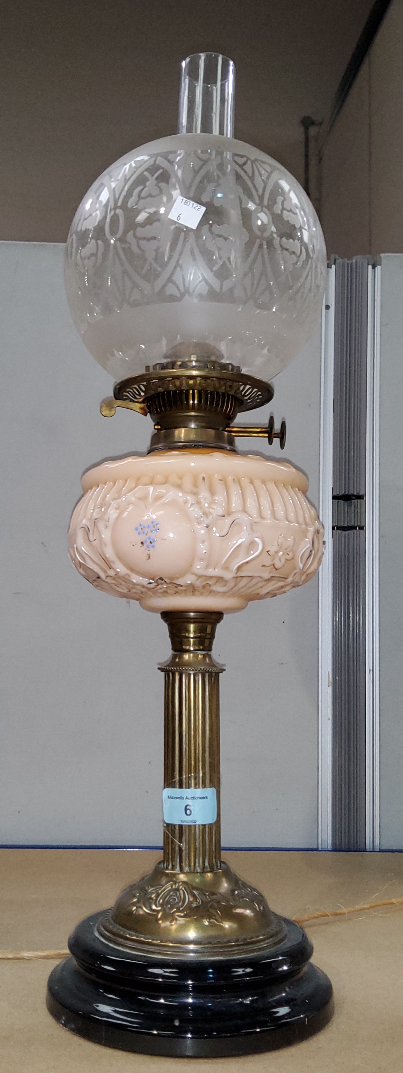 A Victorian oil lamp with brass collar and opaque pink reservoir