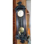 A 19th century Vienna wall clock in ebonised case with raised crest, turned finials and side