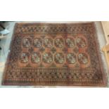 A 20th century hand knotted Persian rug, rust ground with 12 elephant foot motifs to the field, 95 x