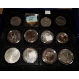 A collection of modern commemorative coins on 3 trays