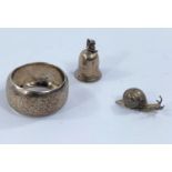 A hallmarked silver napkin ring; a hallmarked silver miniature bell and snail