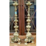 A pair of large, heavy, brass candlesticks, with three feet and turned effect columns, Height 54cm.