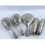 A late Victorian silver cased 5 piece dressing table set, with hand mirror, all decorated with