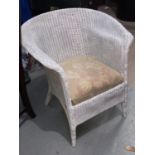 A white Lloyd Loom armchair; a towel rail; an Alibaba basket