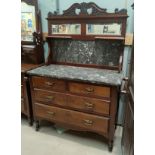 An Edwardian walnut washstand with 2 long and 2 short drawers with brass drop handles, marble top