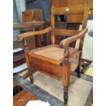 A late 19th/early 20th century commode chair with hinged rush seat