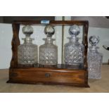 An Edwardian oak tantalus with 3 bottles (no handle; 1 stopper chipped); a spare decanter