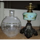 A Victorian cast iron oil lamp with turquoise floral reservoir, chimney and shade