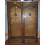 A 1930's oak bookcase enclosed by coloured and leaded glass doors