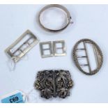 A hallmarked silver nurse's buckle, other silver buckles and a hinged bangle.