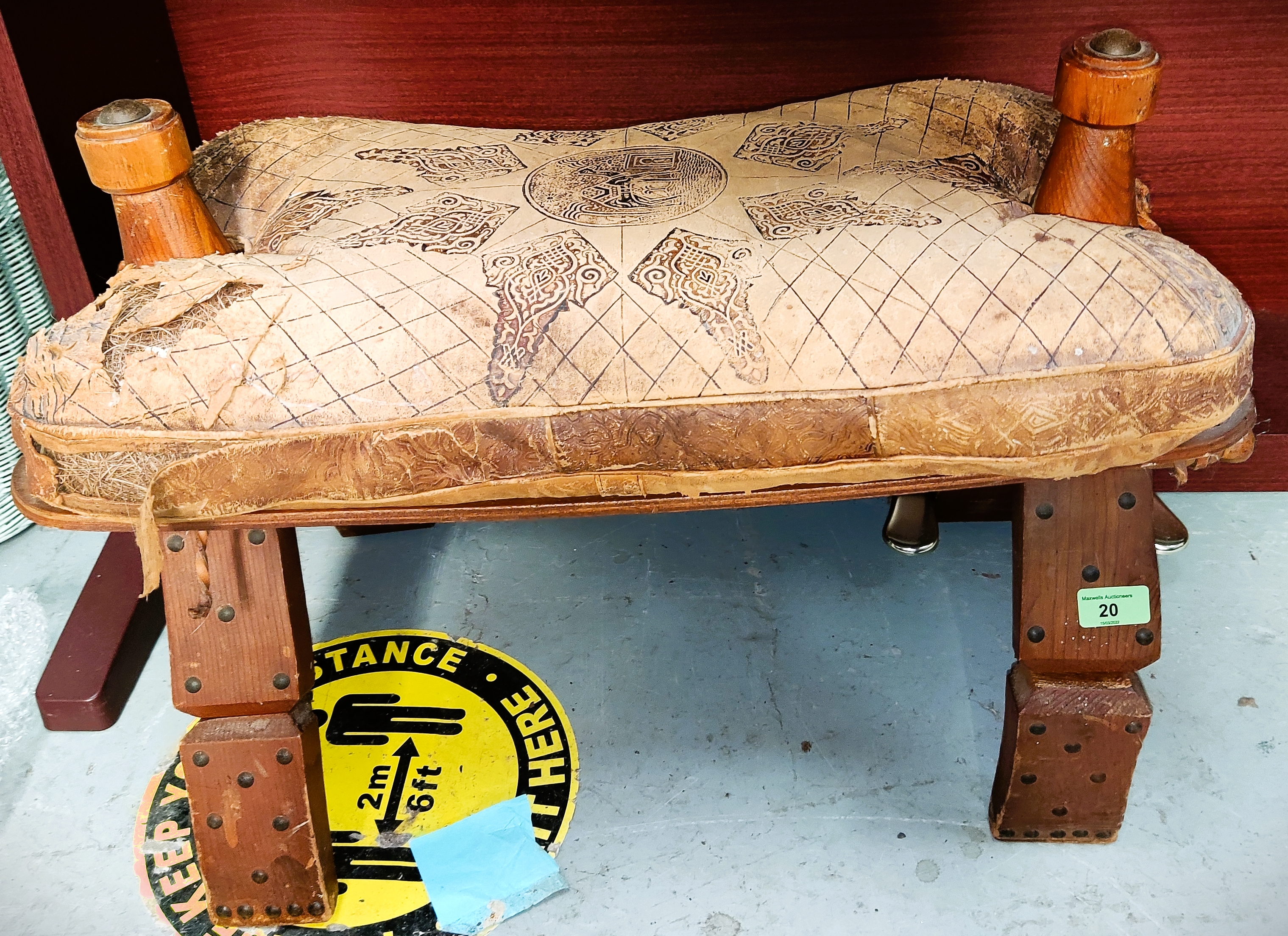 A vintage camel stool with metal studding