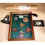 A framed collection of military cap and other badges and scroll certificates relating to the