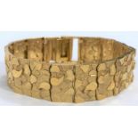 A 9ct hallmarked gold bracelet each link set with raised, polished and matt motifs, 27.2gms