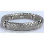 A white gold sectioned bangle with cross hatched links, the centre link pierced and diamond