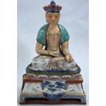 A Chinese ceramic figure of a Buddha in seated lotus position with hole to back possibly for wall