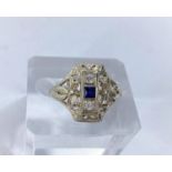 An Art Deco lady's dress ring set with square cut central sapphire and 2 diamonds in raised