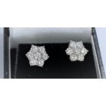 A pair of white metal earrings each with 7 diamonds in flower head setting (pierced) 2.8gms