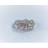 An 18ct hallmarked white gold diamond cluster dress ring set with 3 baguette cut diamonds surrounded