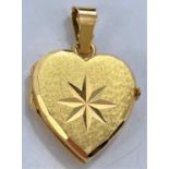 A matt yellow metal heart shaped locket pendant with star motif, loop stamped "750", 7.9gms