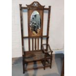 An Arts & Crafts hall stand with mirror back, seat and 2 stick stands