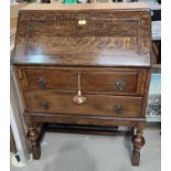 A 1930's oak bureau with fall front and 2 drawers under