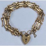 A yellow metal gate bracelet with 9ct hallmarked gold heart lock, 8.3gms