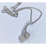 An 18ct hallmarked white gold pendant set with 2 flower head diamond clusters on fine chain, 5.4gms