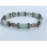 A vintage bracelet formed from oblong jade coloured stones joined by white metal links of Chinese
