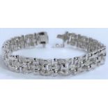 A white metal gate bracelet, central 9 links encrusted with diamonds, stamped '18K', 36.4gms