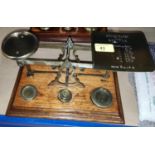 A set of balance scales:  "Postal Rates for Letters", with weights on oak plinth