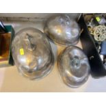 A graduating set of 3 domed oval silver plates meat covers (worn and dented)