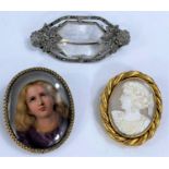 A Victorian female head cameo in rope twist gilt metal surround; a porcelain brooch depicting a