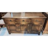 A Georgian style distressed oak sideboard with 3 drawers and 3 arch panel doors