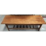 A mid 20th century long teak coffee table with ladder shelf under length 122cm