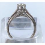 A white metal solitaire brilliant cut diamond ring in raised setting, 9 graduating diamonds to