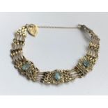A 9 carat hallmarked gold  gate bracelet set with 3 aquamarine coloured stones, gross 8gm