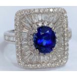An 18ct white gold Art Deco style dress ring set with an oval sapphire in rectangular 3 tier setting