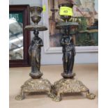 A pair of candlesticks with bronze classical figure columns, square embossed bases on paw feet,