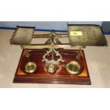 A set of balance scales:  "Postal Rates for Letters", with weights on inlaid mahogany plinth