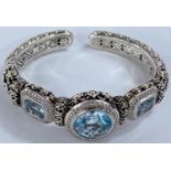 John Hardy, an intricate pierced silver bangle with central circular blue topaz flanked by 2