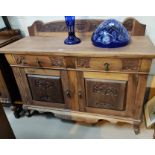 An Edwardian sideboard in stripped and refinished  carved walnut, comprising 2 cupboards and 2