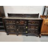 A 19th century oak dresser base with geometric moulded decoration with central arched cupboard and 7