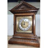 An Edwardian mantel clock in architectural oak case, with striking movement