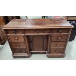 A Victorian mahogany kneehole dressing table with 7 drawers and central recessed cupboard