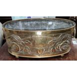 A brass oval planter in the Arts and Crafts manner with Macintosh style roses, double handles length