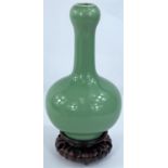 A Chinese green enamelled porcelain onion form vase, 20cm and hardwood stand (Good condition)