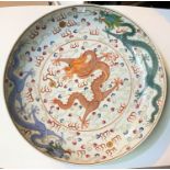 A large Chinese charger decorated with central orange dragon, with other dragons to the border in