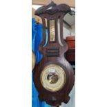 An early 20th century barometer with thermometer in oak case