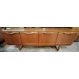 A 1960's teak lowline sideboard with 4 cupboards, by Stonehill